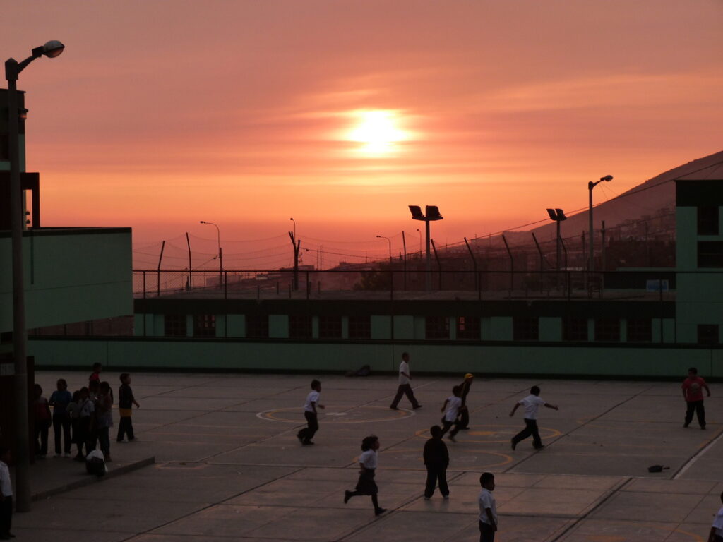 A Pachacútec, les enfants profitent d'un coucher de soleil pour jouer dans la cour.